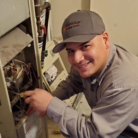 A North Star Heating and Air Conditioning HVAC tech repairing an AC unit in Sandy, Utah. 
