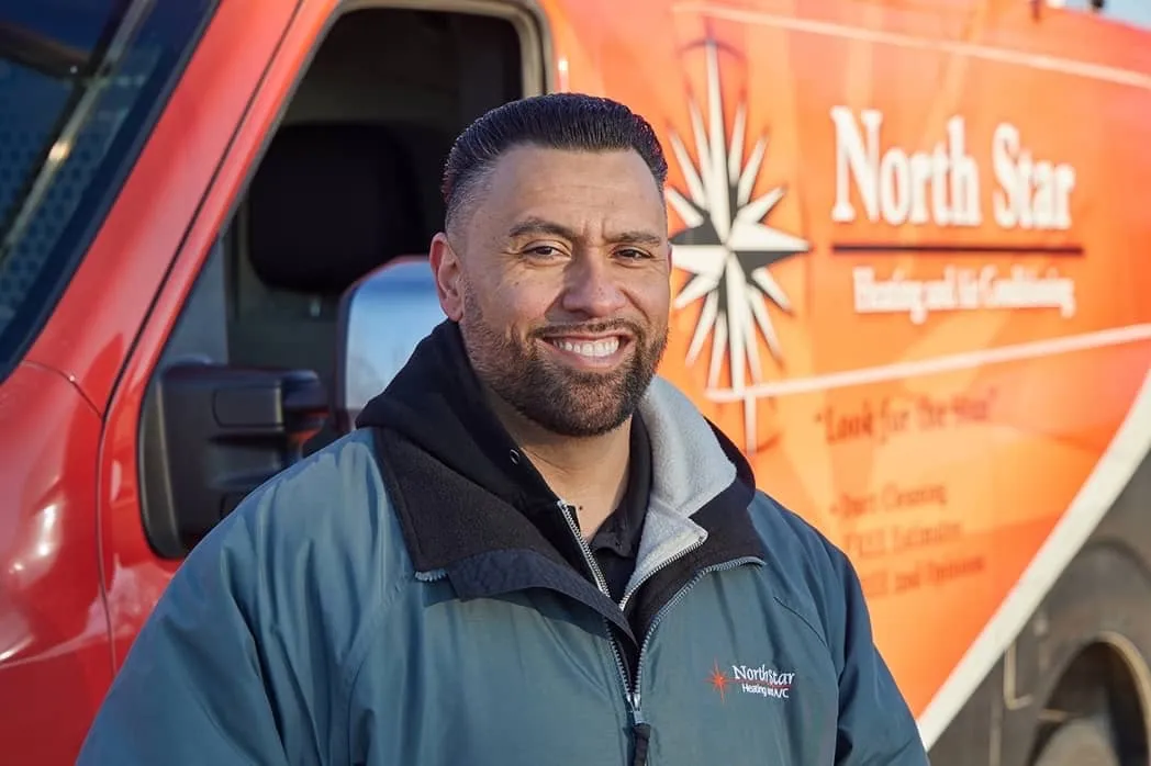 North Star team member smiling in front of service van