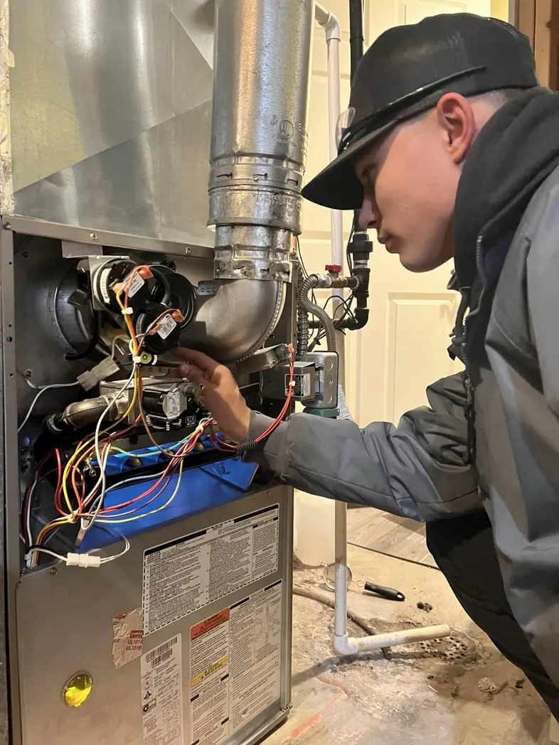 Technician repairing a furnace in Sandy