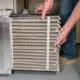 man changing dirty air filter