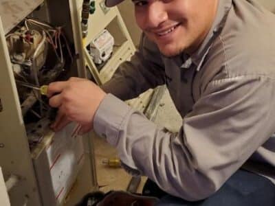 A North Star Heating & Air Conditioning HVAC technician work on an HVAC system for maintenance.